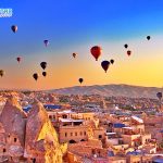 Sunrise in Cappadocia, Turkey, with balloons and typical fairy chimney
